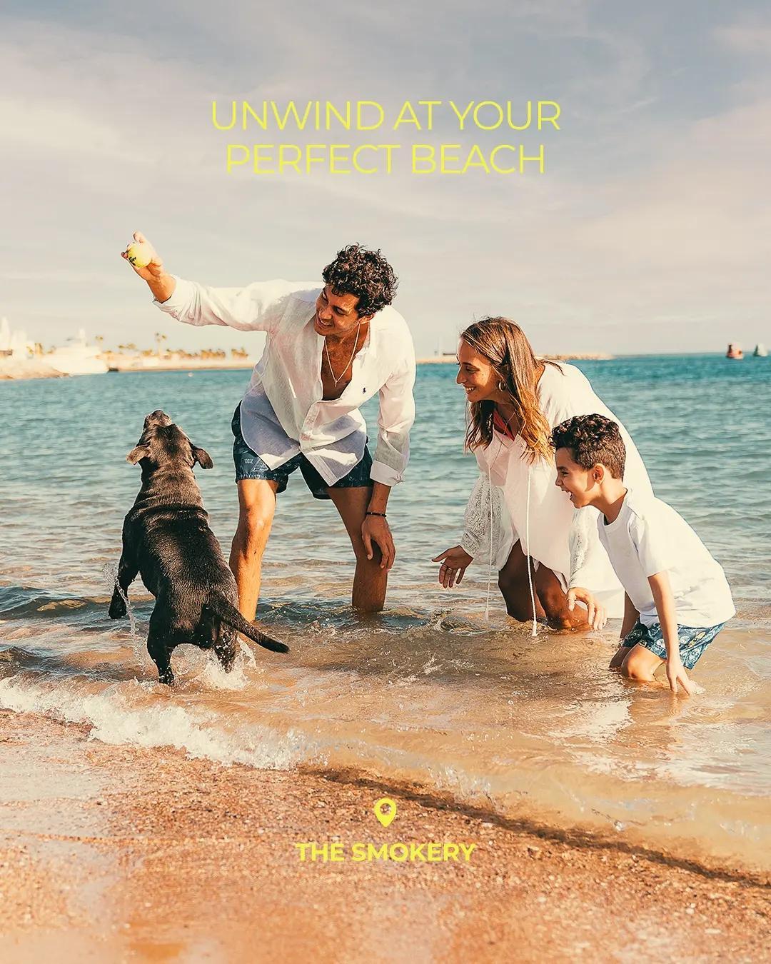 Family enjoying a relaxing beach day with their dog at The Smokery in El Gouna.