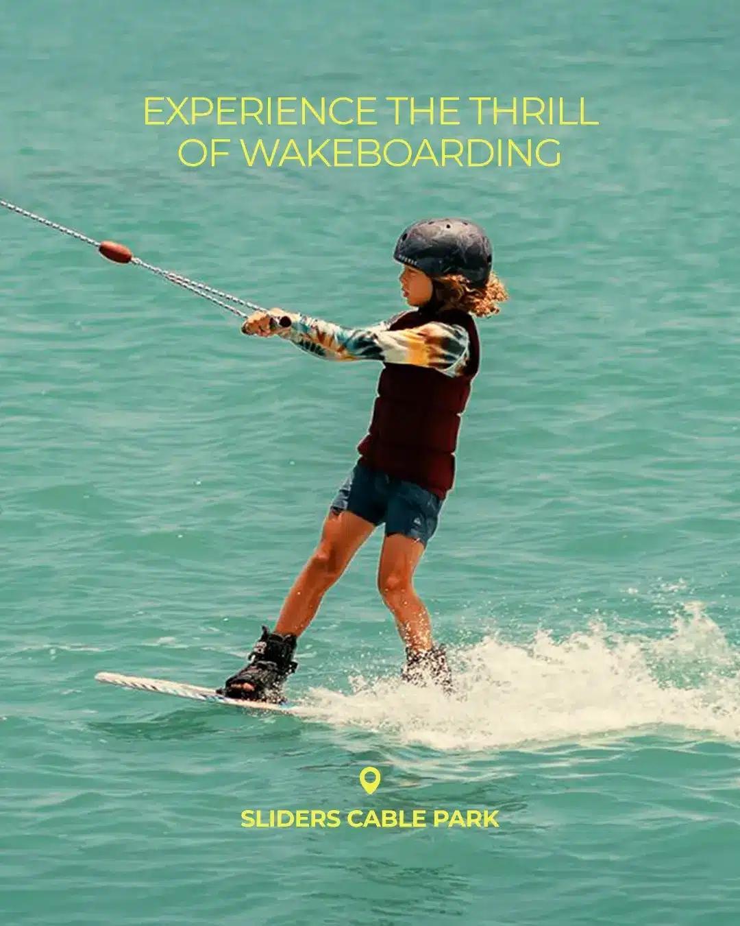 Child wakeboarding on turquoise water at Sliders Cable Park in El Gouna.